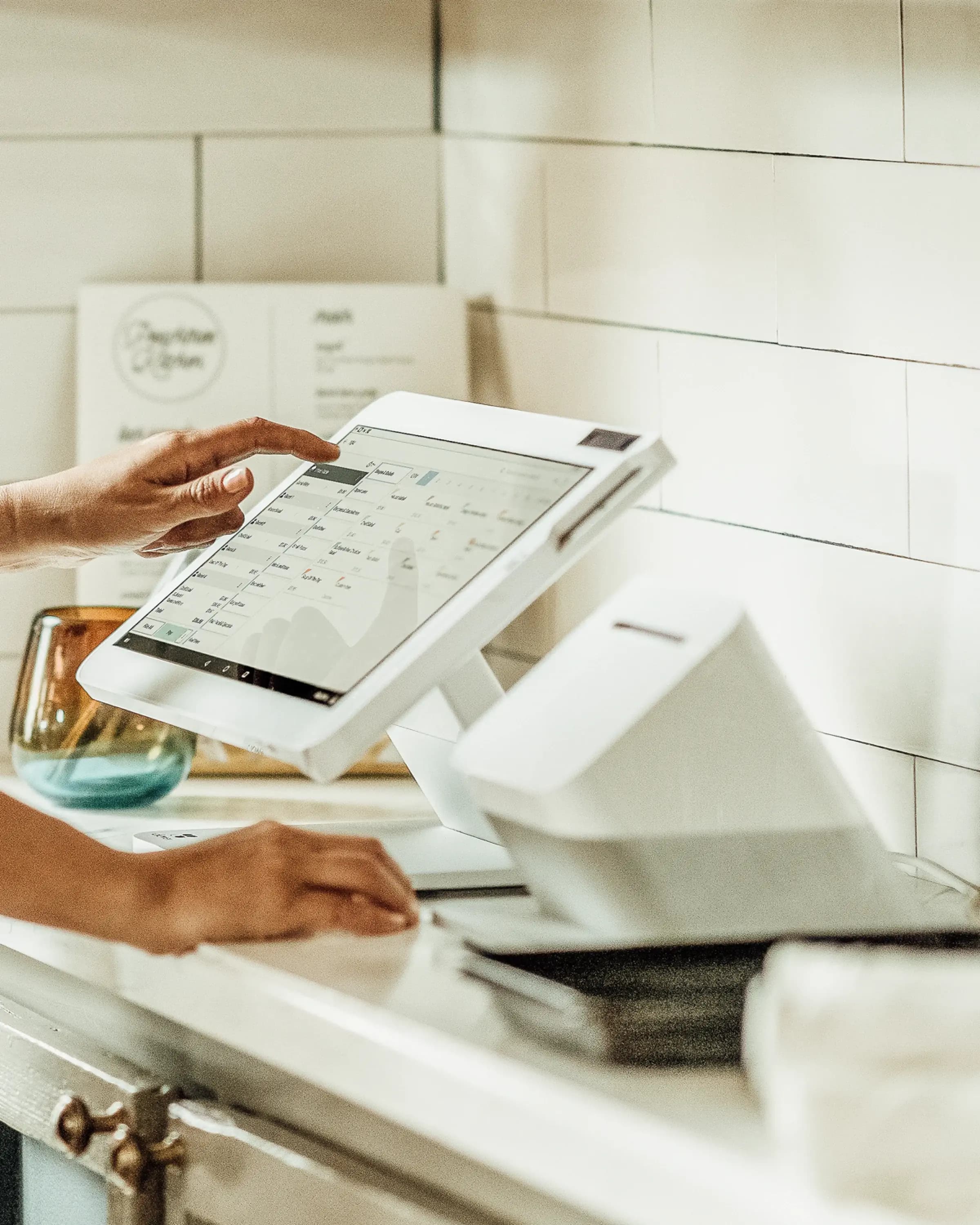 Clover Station Solo and receipt printer on a bright white counter with subway tile backsplash